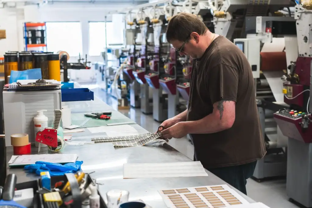 Technician working on label printing presses on the factory floor
