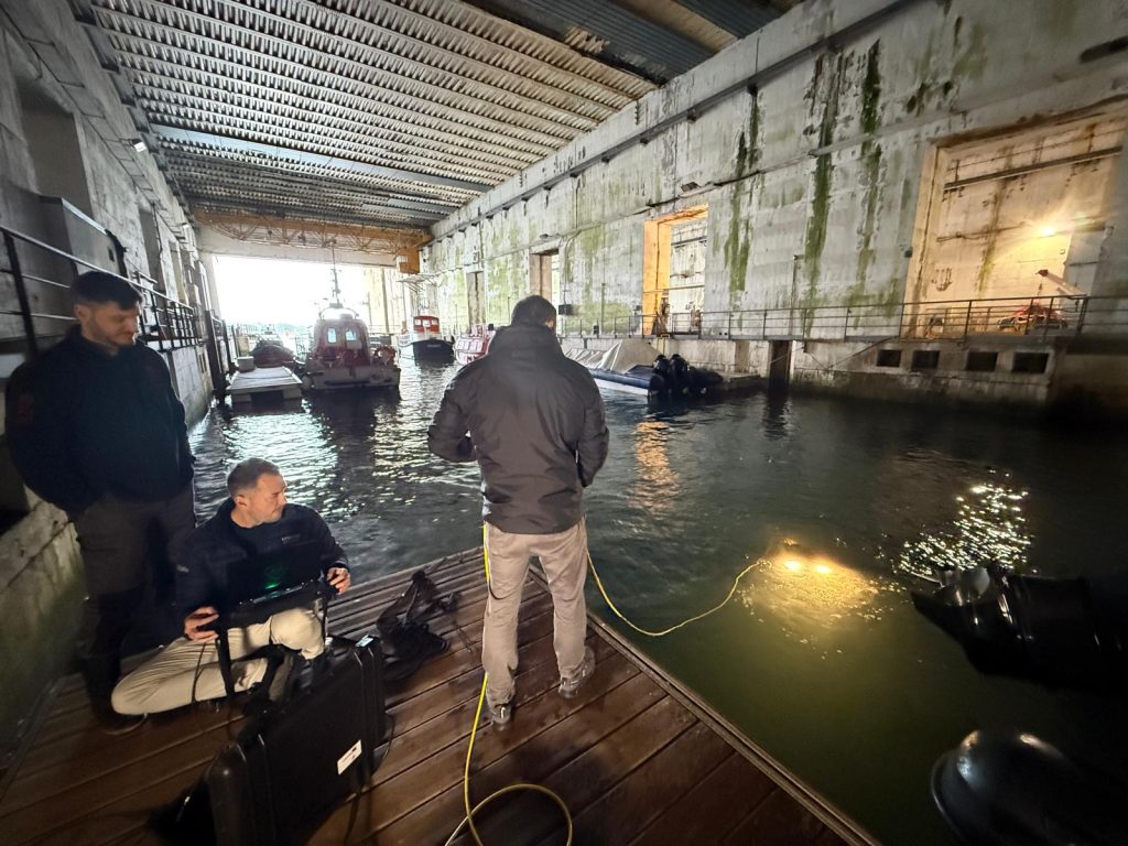 Team preparing subsea equipment in a covered dock